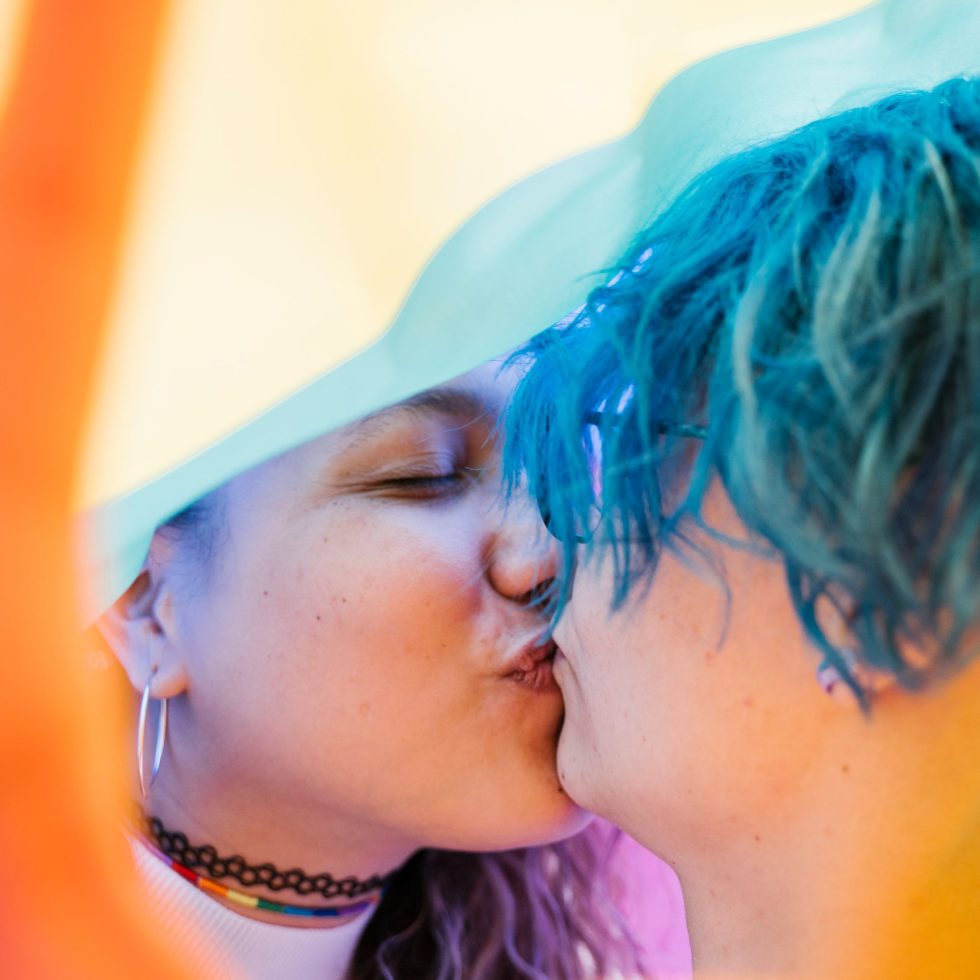 Kaksi nuorta suukottaa, edsessä käden kuva.
